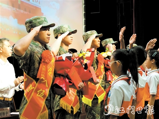 小學(xué)生代表向入伍新兵代表獻(xiàn)上鮮花。