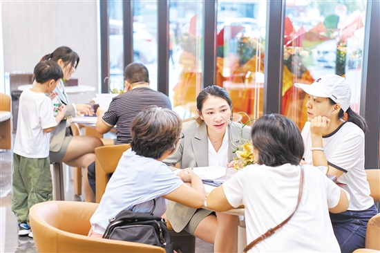 今年國慶假期，全市主要房地產(chǎn)項(xiàng)目認(rèn)購近2300套,圖為銷售人員在接待客人。