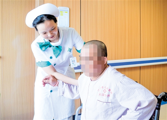 護(hù)士攙扶雙下肢無力患者上病床。