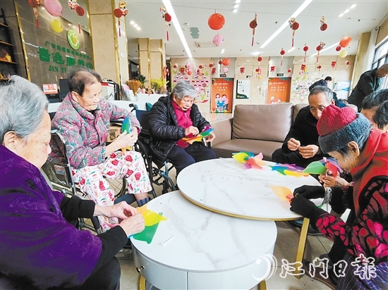 老人們圍坐在桌前，專注地制作小風車。