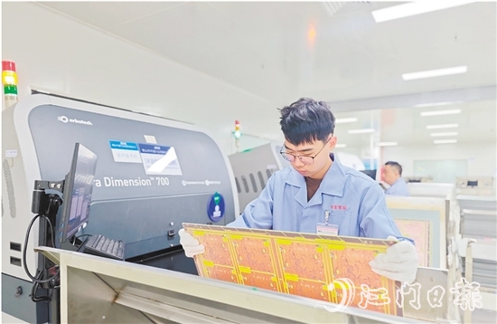 在鶴山中富生產(chǎn)車間，員工操作自動化設(shè)備趕制電路板。