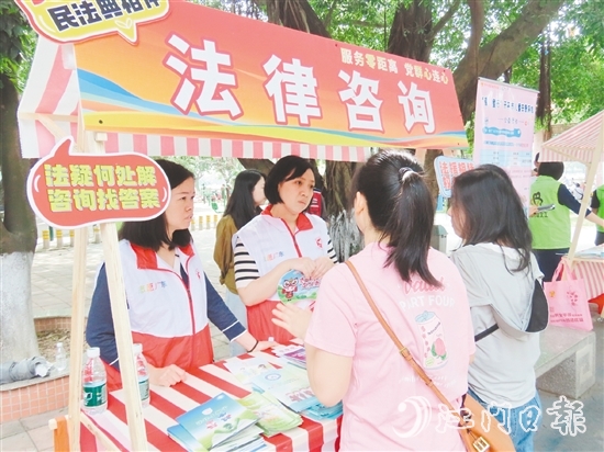 在法律援助攤位，司法系統(tǒng)黨員志愿者耐心解答群眾的法律咨詢。