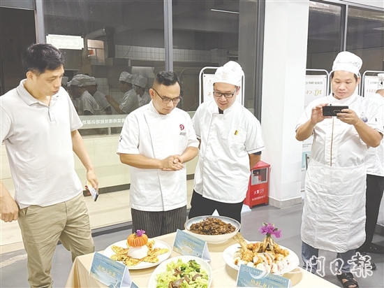 伍立更（左二）對學員們的自創(chuàng)菜式一一進行點評和指導。