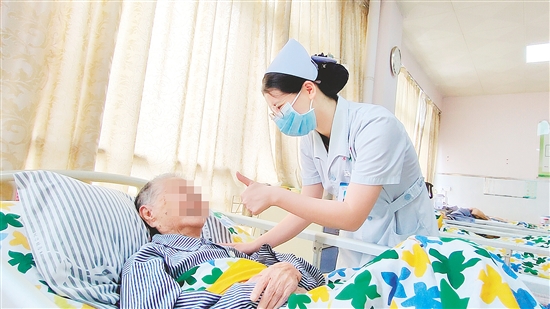 這是一雙傳遞溫度的手?！坝袝r(shí)去治愈，常常去幫助，總是去安慰”，江門市第三人民醫(yī)院內(nèi)科護(hù)士容海清站在床邊，將大拇指高高豎起，用輕柔的話語與溫暖的肢體語言，鼓勵(lì)臥床患者樹立康復(fù)的信心。