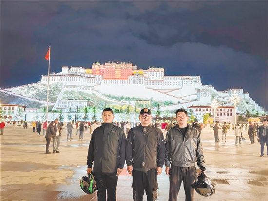 余鴻威（左一）與摩友在拉薩布達拉宮前合影留念。