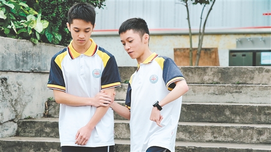 校園里，弟弟（左）和哥哥（右）相互扶持。