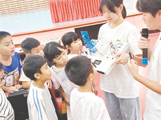 服務隊隊員向孩子們展示氫燃料電池演示儀。