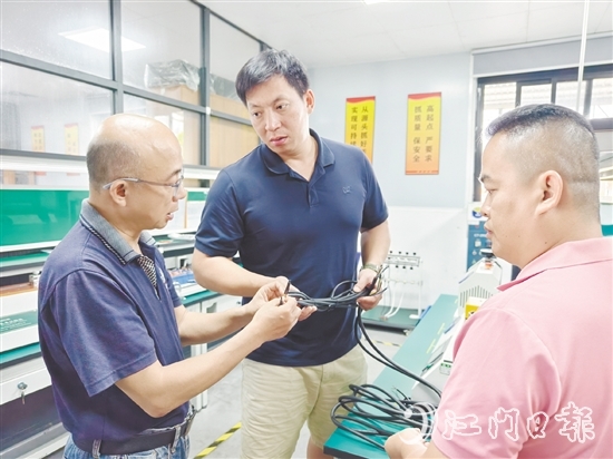 盧慶忠（中）與技術(shù)人員交流產(chǎn)品質(zhì)量問題。