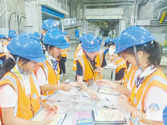 在江門中微子實(shí)驗(yàn)室實(shí)驗(yàn)大廳，學(xué)生們分組進(jìn)行實(shí)驗(yàn)。