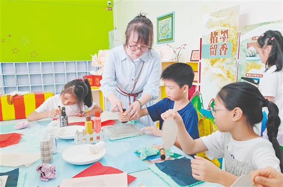 在導(dǎo)師的指導(dǎo)下，孩子們紛紛拿起紙張，在拓板上謹(jǐn)慎操作。