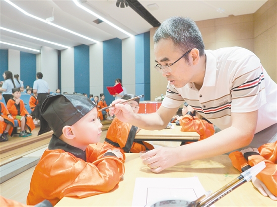 在朱砂啟智環(huán)節(jié)，教師用毛筆在新生的額頭點上紅痣。