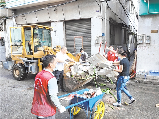在蓬江區(qū)環(huán)市街道里村社區(qū)舊村片區(qū)，人和機(jī)器齊上陣，清理衛(wèi)生死角。