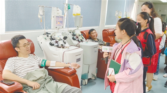 小記者采訪正在獻血的志愿者。