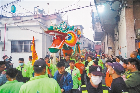 村民們高舉金龍，穿街過巷進行巡游。