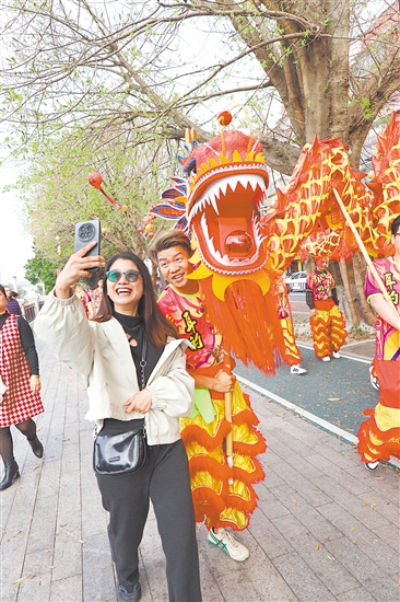 春節(jié)期間，江南路金龍巡游，吸引市民駐足合影。