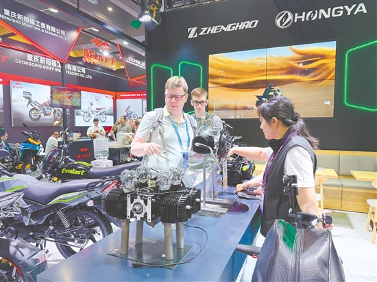 在正豪摩托展位，工作人員為外國(guó)客商介紹摩托車零部件。