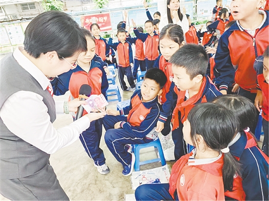 宣講員以第五套人民幣為教具，讓孩子們學(xué)會(huì)識(shí)假技巧。