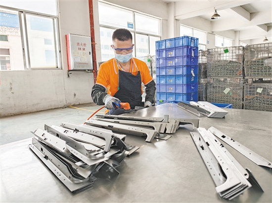 在江門市華譽(yù)制造有限公司的生產(chǎn)車間，52歲的殘疾人員工黃日道在認(rèn)真打磨零部件。