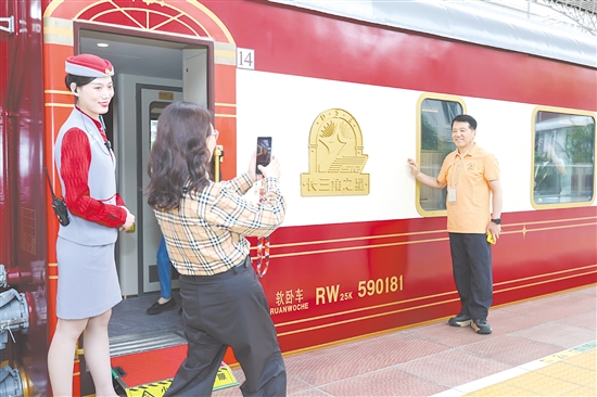 5月19日，長(zhǎng)三角地區(qū)首趟舒適型旅游列車“長(zhǎng)三角之星”從鐵路上海西站始發(fā)，旅客在登車前拍照留念。新華社發(fā)
