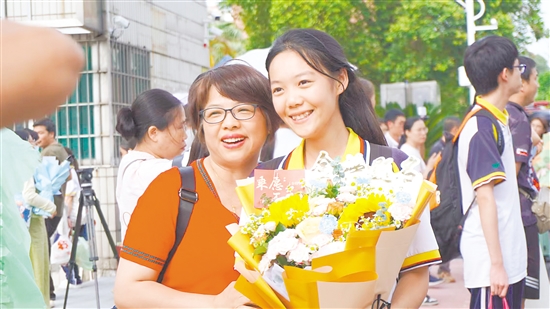 考生捧花與家長合影。
