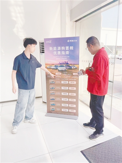 銷售人員向市民介紹優(yōu)惠政策。